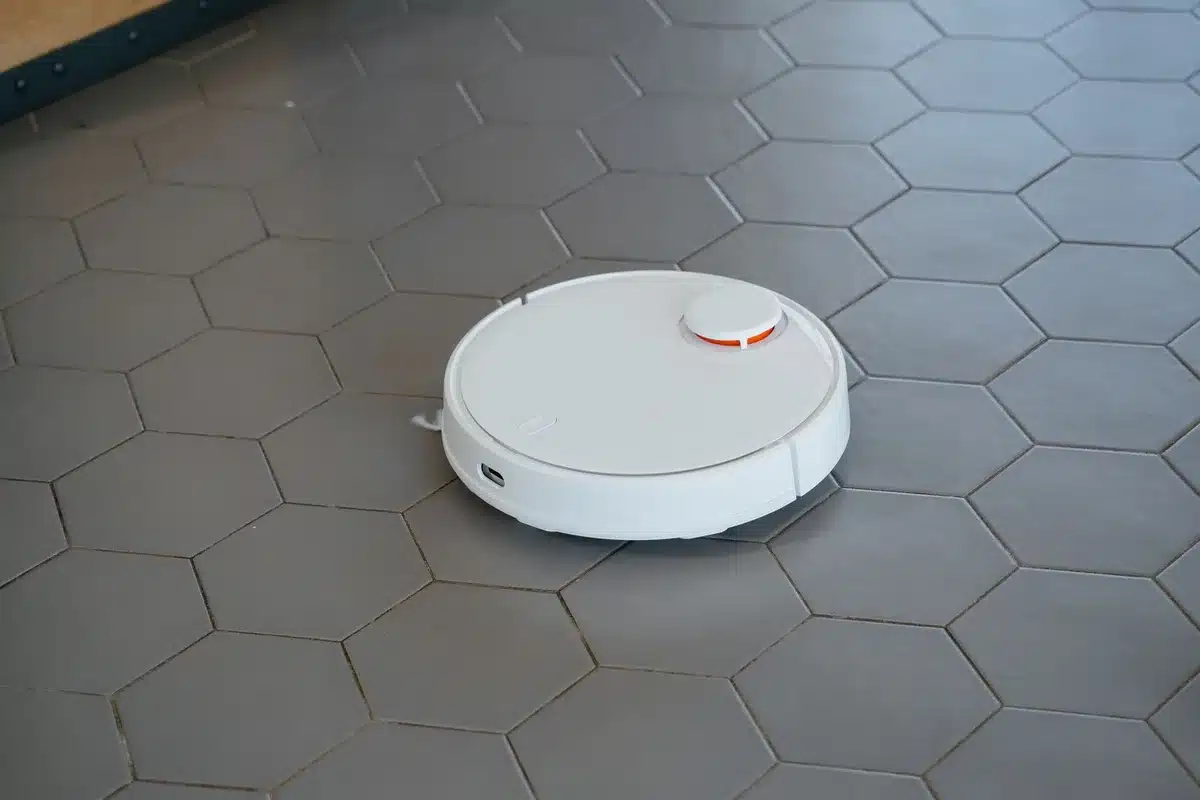 Robot aspirapolvere e lavapavimenti con rullo autopulente durante il ciclo di pulizia