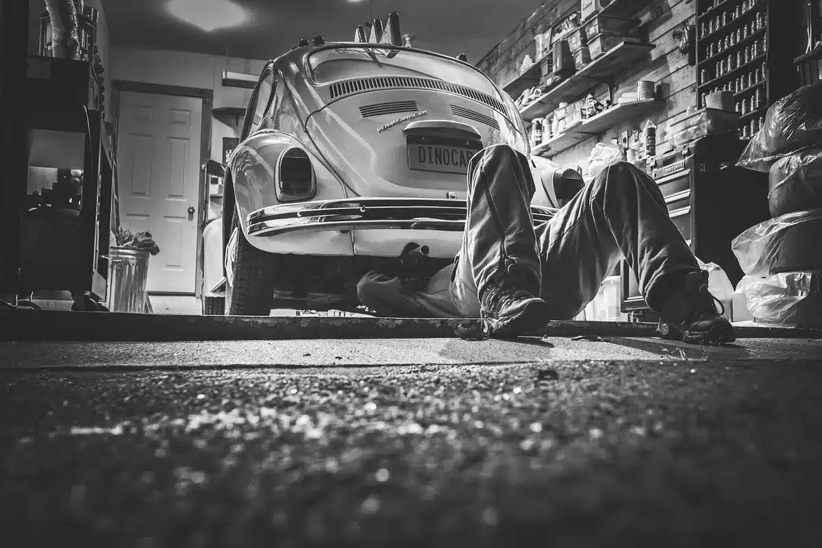 Meccanico che ispeziona un'auto usata più datata in un'officina