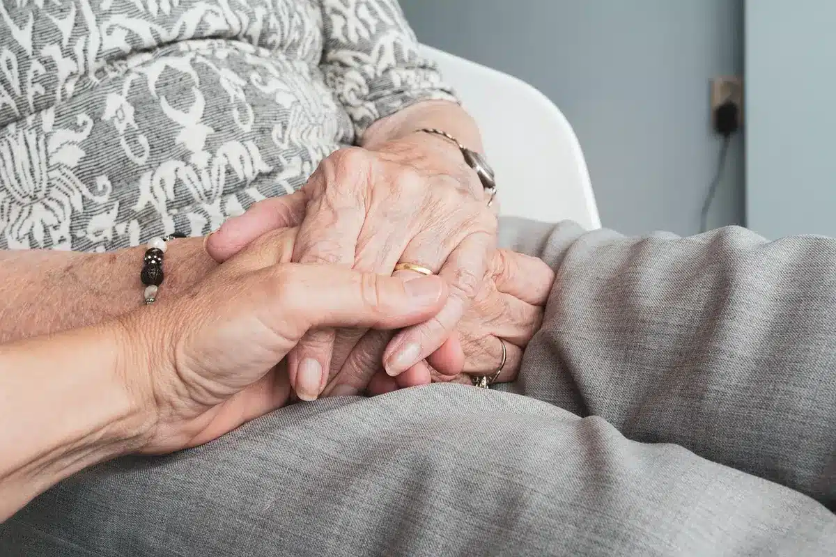 Tre persone in conversazione seria, una donna al centro circondata da supporto familiare