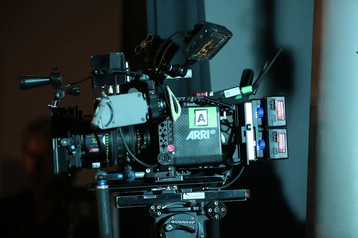 Mani che tengono un controller mentre uno schermo mostra una scena cinematografica, simbolo dell'integrazione tra gioco 