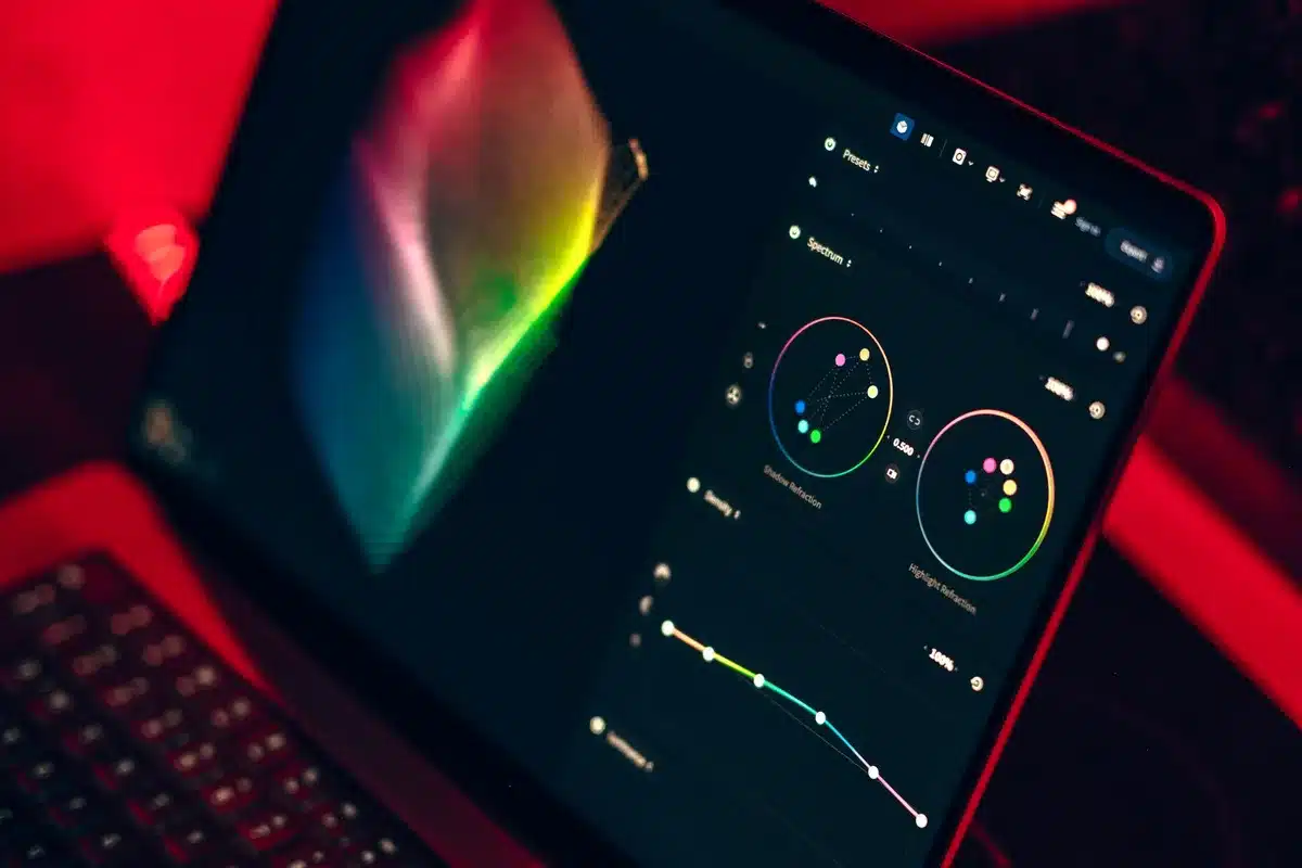 Mani che digitano su un laptop con strumenti creativi che emergono dallo schermo