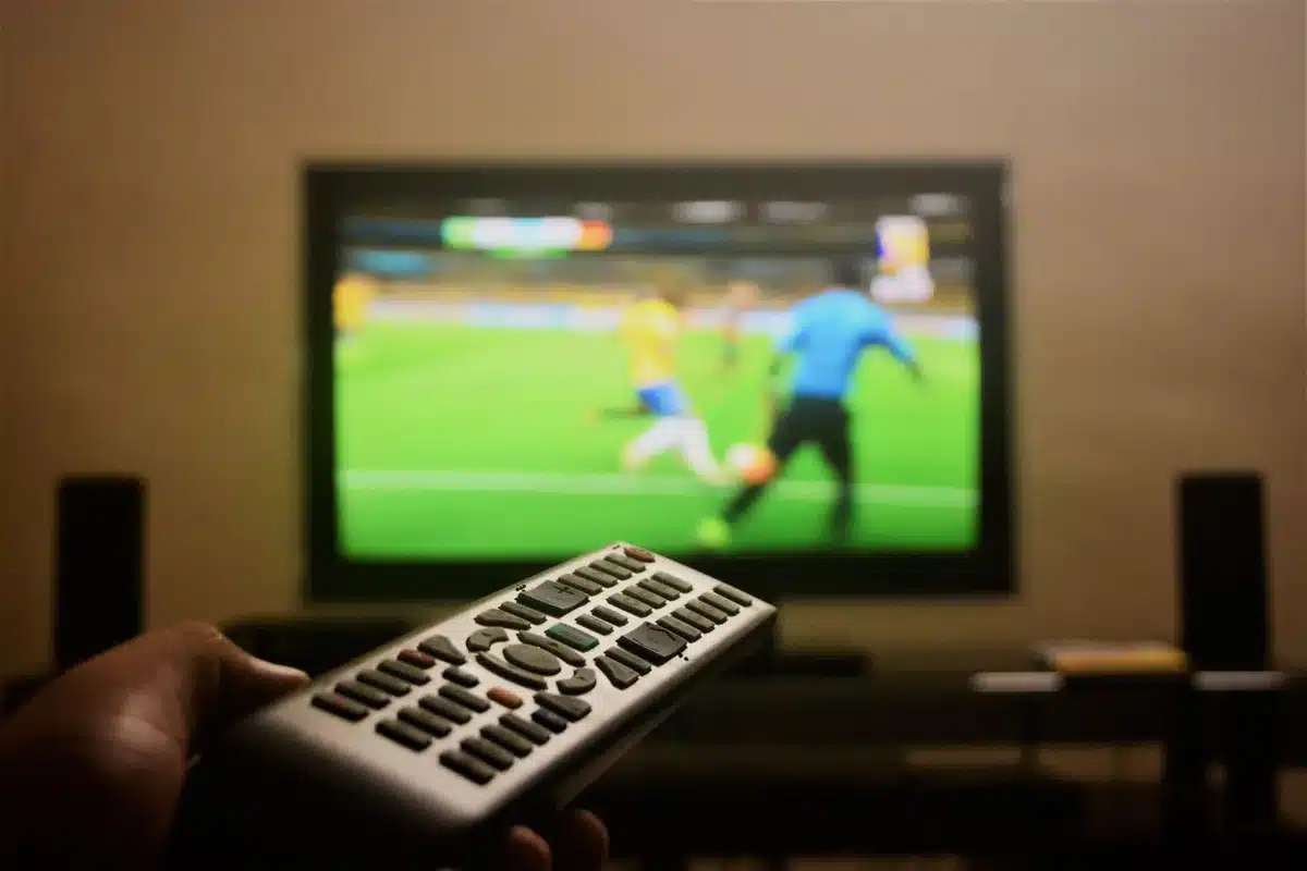 Telecomando TV con menu delle impostazioni audio visibile sullo schermo