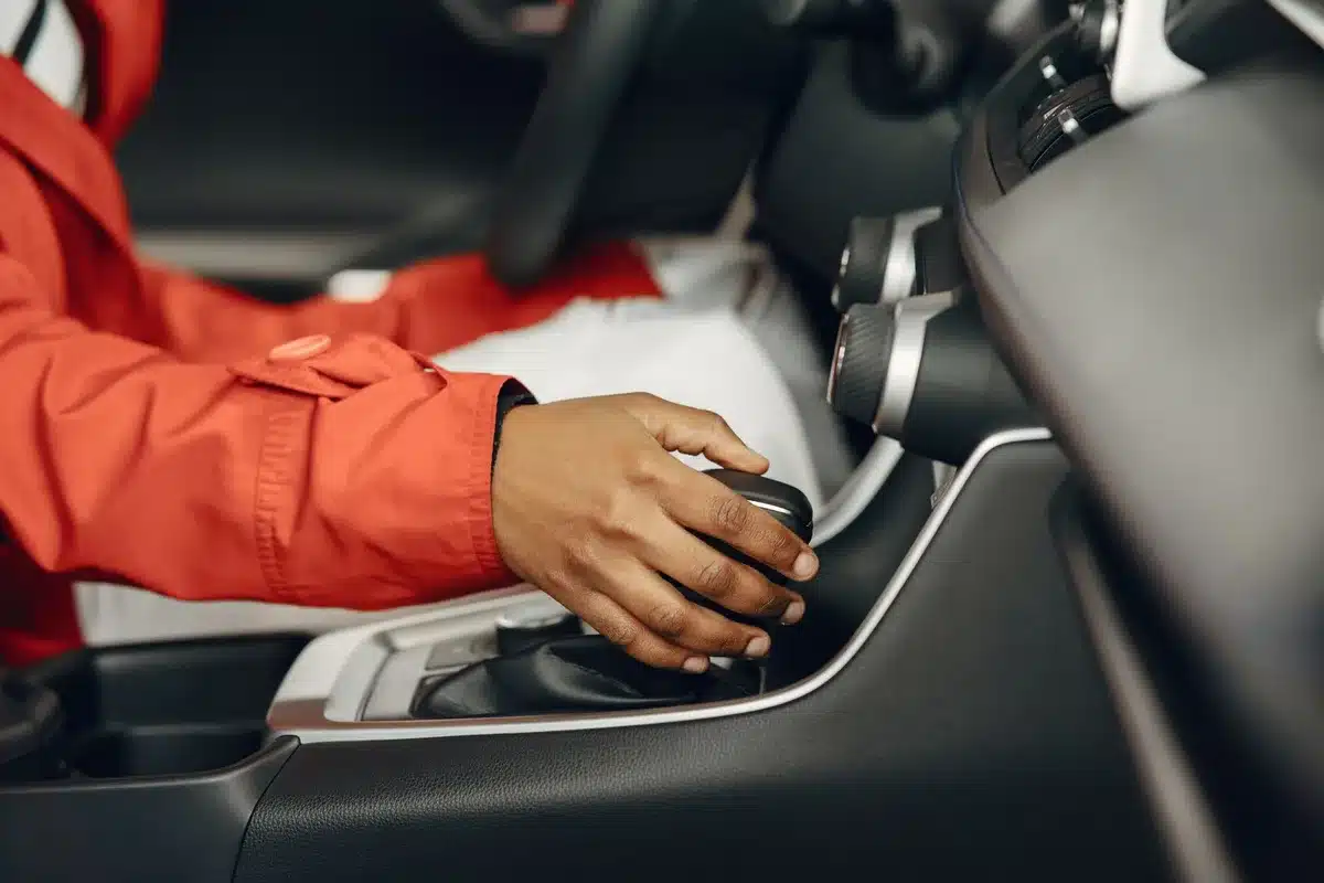 Mani su una leva del cambio manuale all'interno di un cockpit di supercar