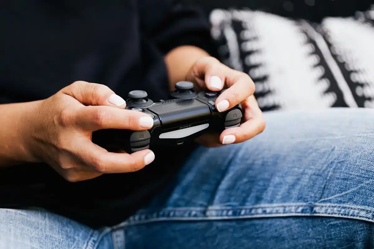 Mani che impugnano un controller wireless da gaming con finitura scura e dettagli metallici