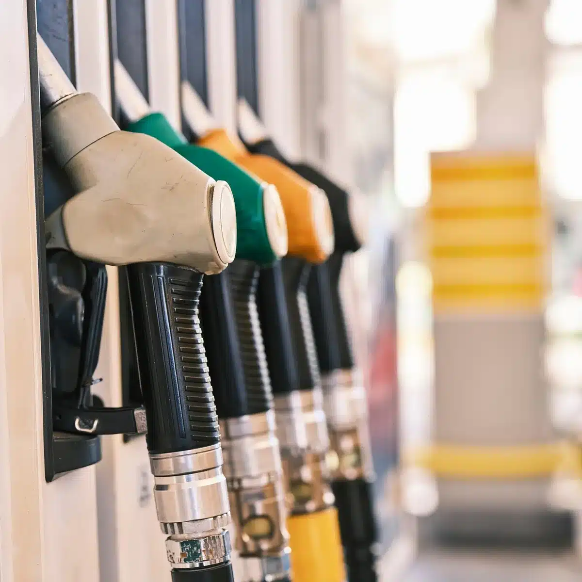 Distributore di carburante con pompe self-service e prezzi in primo piano