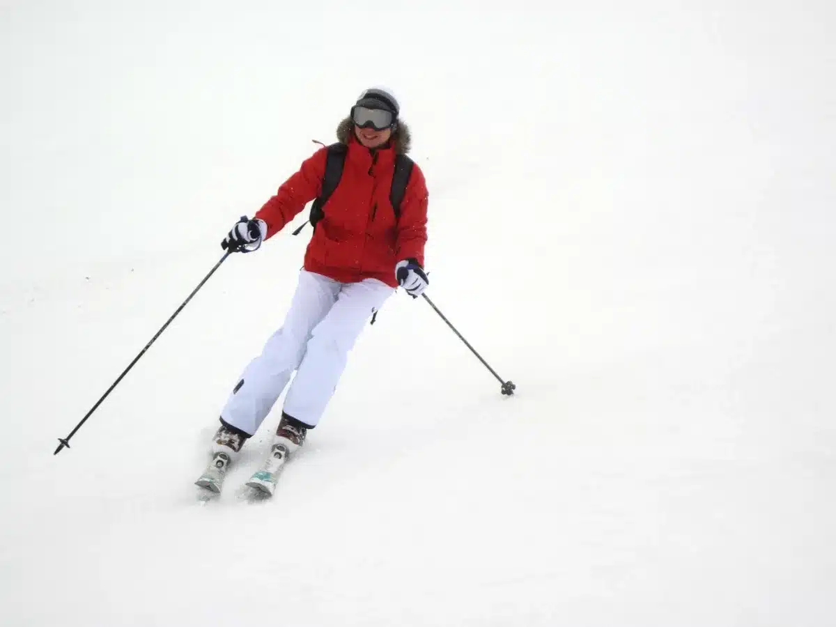 Sciatore in discesa su pista innevata con rilevamento curve e forza G