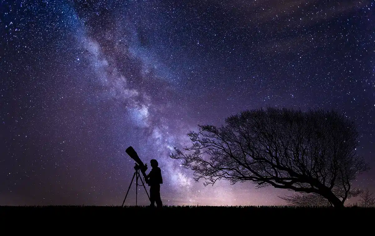 Astronomo amatoriale con telescopio in giardino che osserva il cielo
