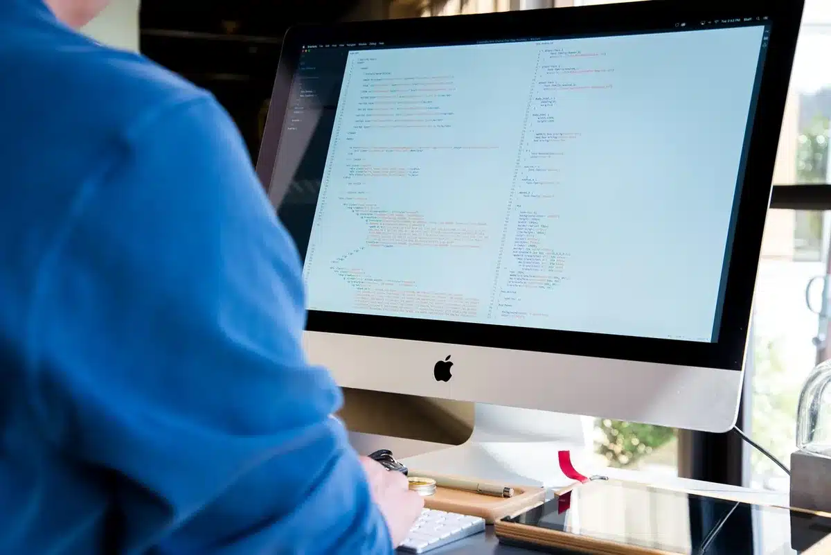 Sviluppatore che lavora da solo al computer, affaticato dalla manutenzione di un progetto