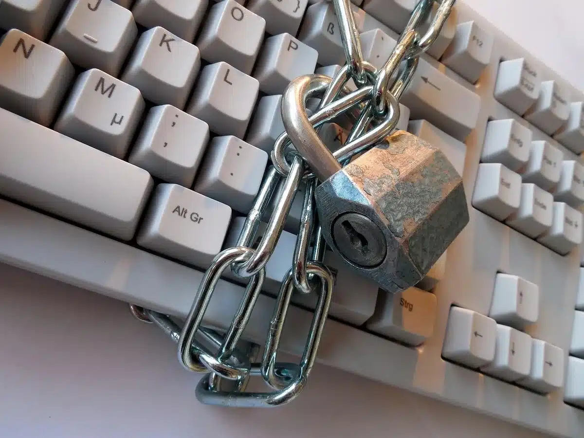 Persona che digita su laptop con icona di lucchetto illuminato sullo schermo, che rappresenta la sicurezza online