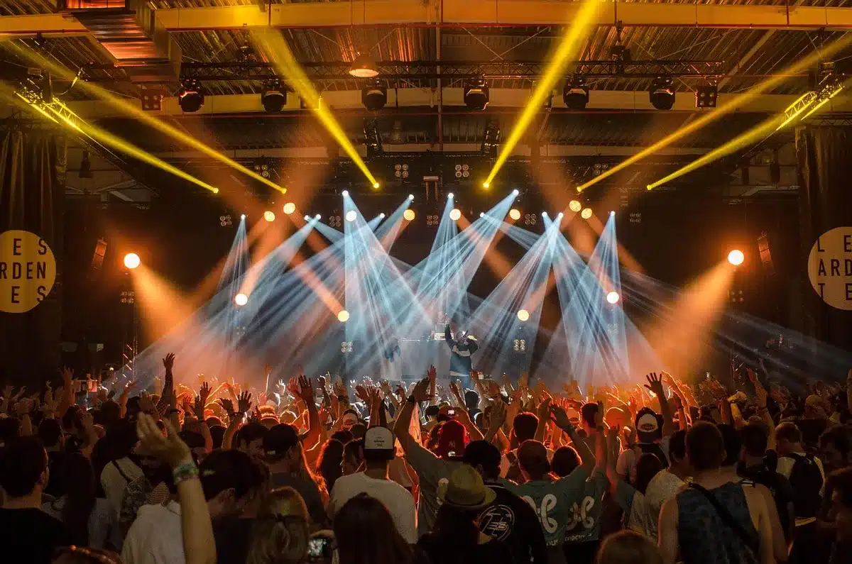 Volti di spettatori di diverse età che reagiscono emotivamente durante un concerto dal vivo.