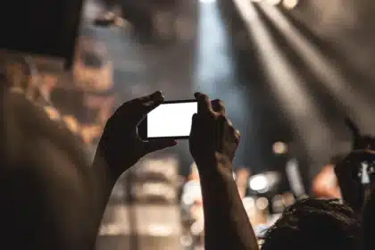 Laptop e smartphone sul tavolino di un corridoio d'hotel, silhouette sullo sfondo
