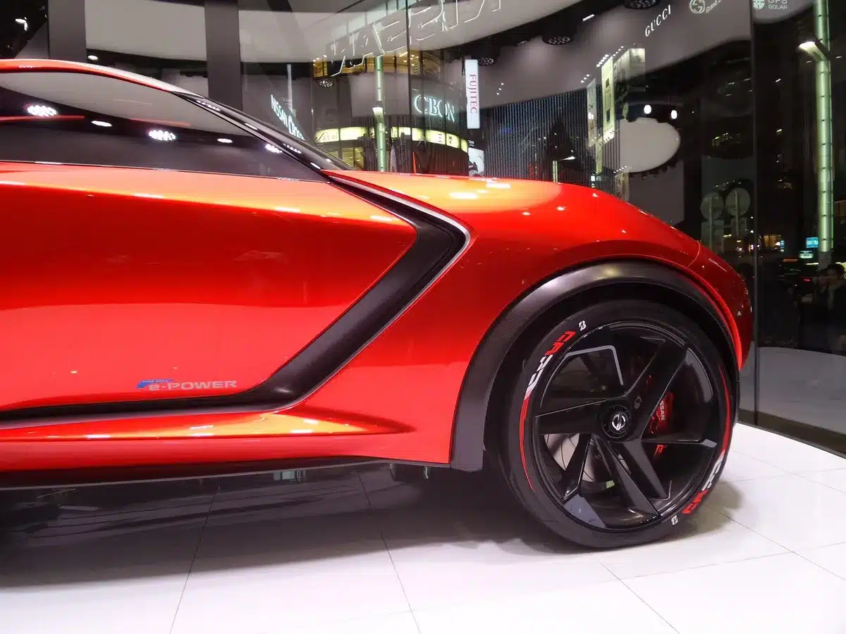 Auto compatta elettrica in esposizione con famiglia vicino