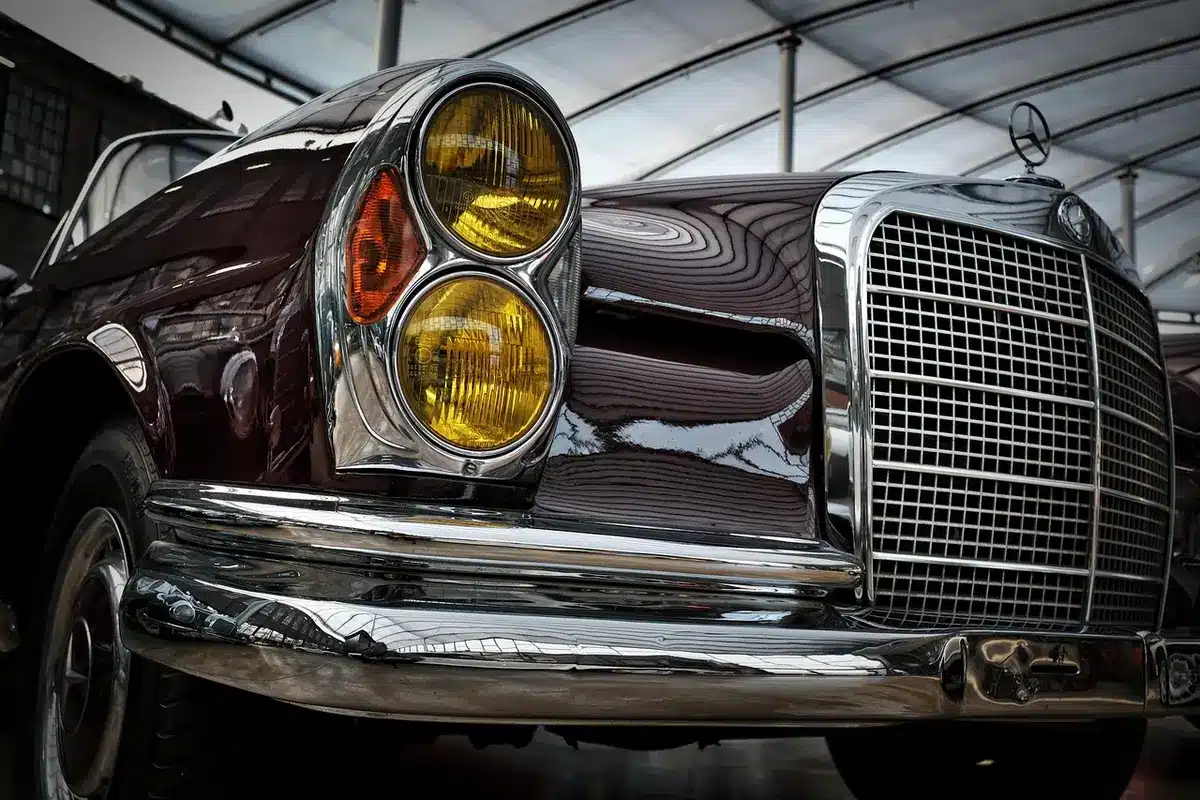 Padiglione espositivo grande con automobili in mostra e visitatori