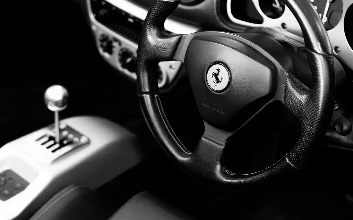Padiglione espositivo con silhouette di automobili e visitatori, vista ampia