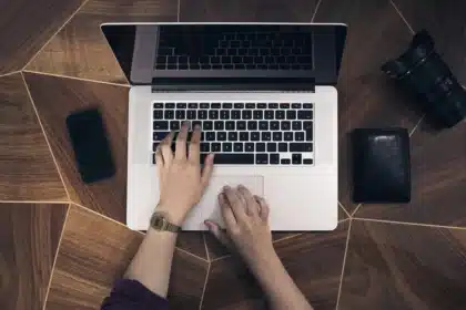 Mani anonime che tengono uno smartphone con notifiche su uno sfondo caffetteria