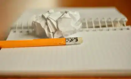 Team anonimo di ingegneri al tavolo con laptop e documenti, luci chiare in ufficio
