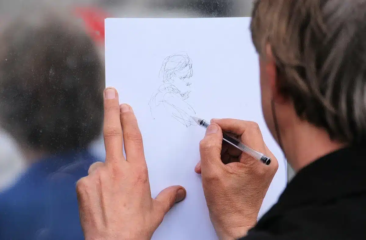 Mano che disegna un fumetto su carta con matita