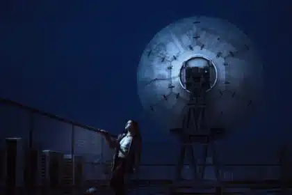 Silhouette di una parabola su un tetto con cielo e satellite in lontananza