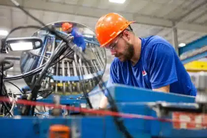 Linea di montaggio auto con silhouette di operai in capannone ben illuminato