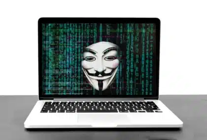 Persona anonima al computer davanti a una finestra browser sfocata e dashboard