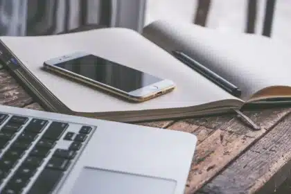 Scrivania con laptop, telefono e appunti, scena di risposta a un incidente informatico