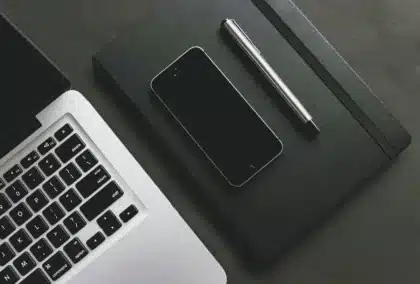 Mani anonime che digitano su smartphone accanto a calendario e promemoria