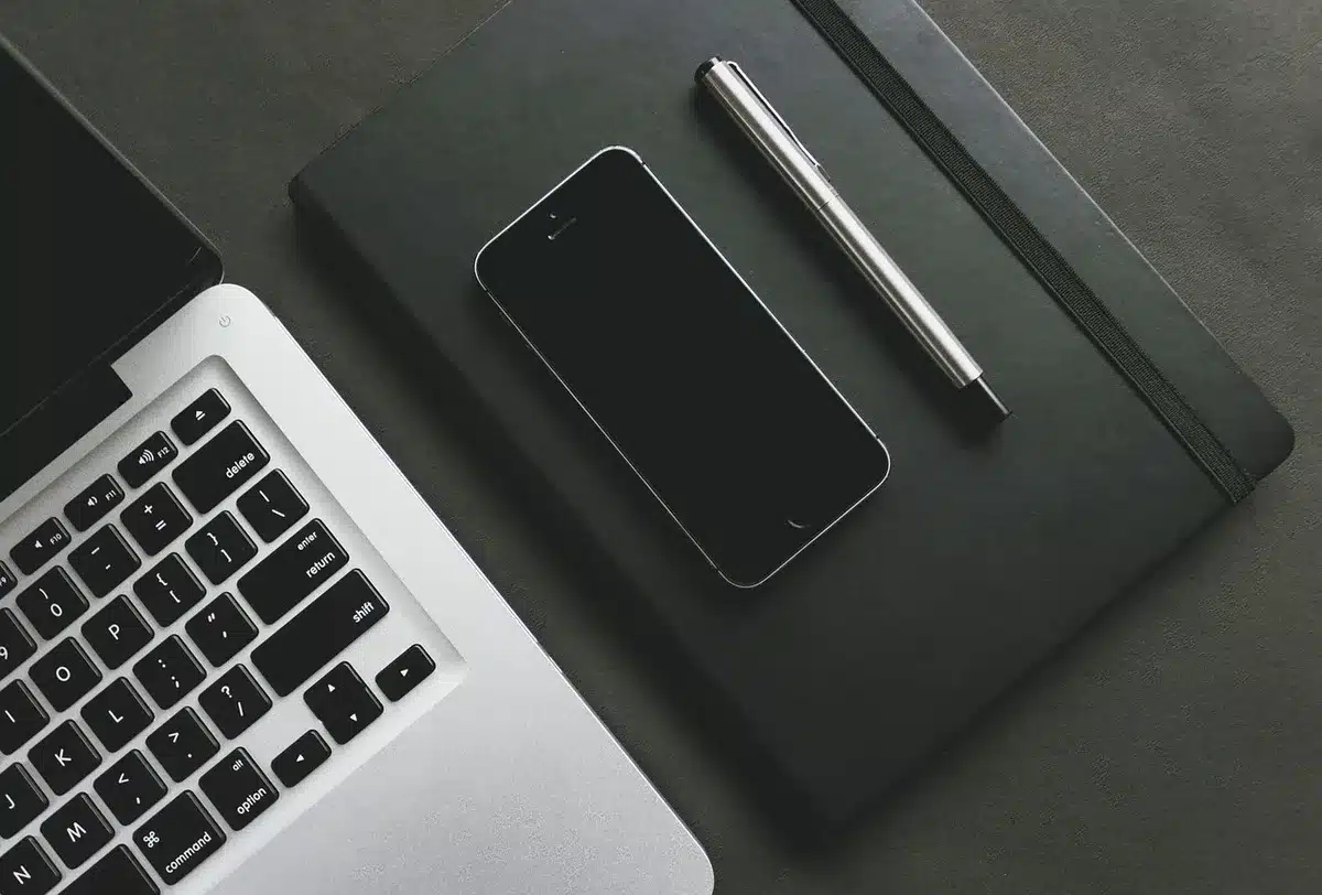 Mani anonime che digitano su smartphone accanto a calendario e promemoria
