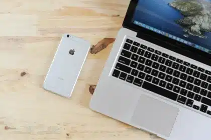Mani che tengono uno smartphone vicino a una SIM su una scrivania