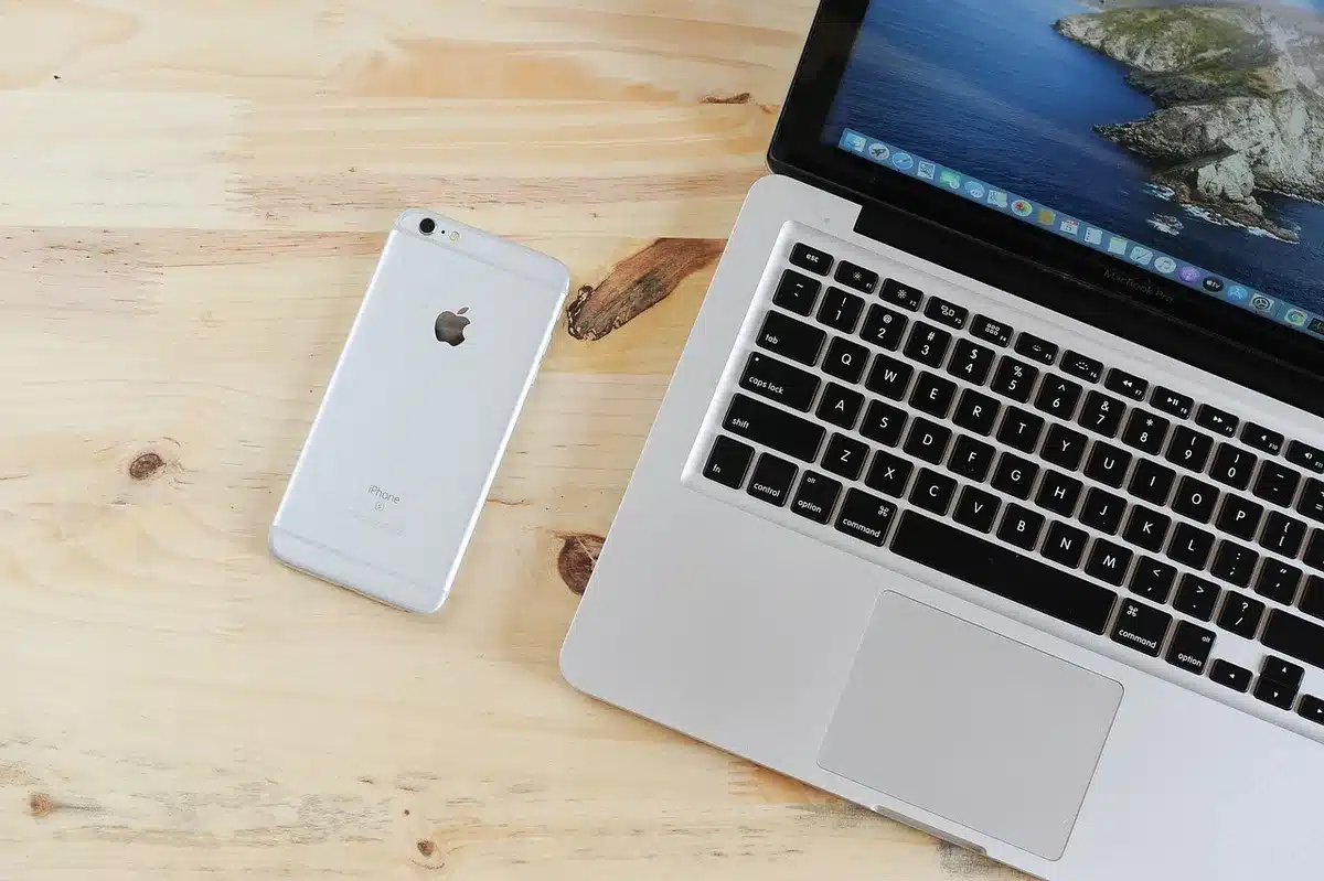 Mani che tengono uno smartphone vicino a una SIM su una scrivania